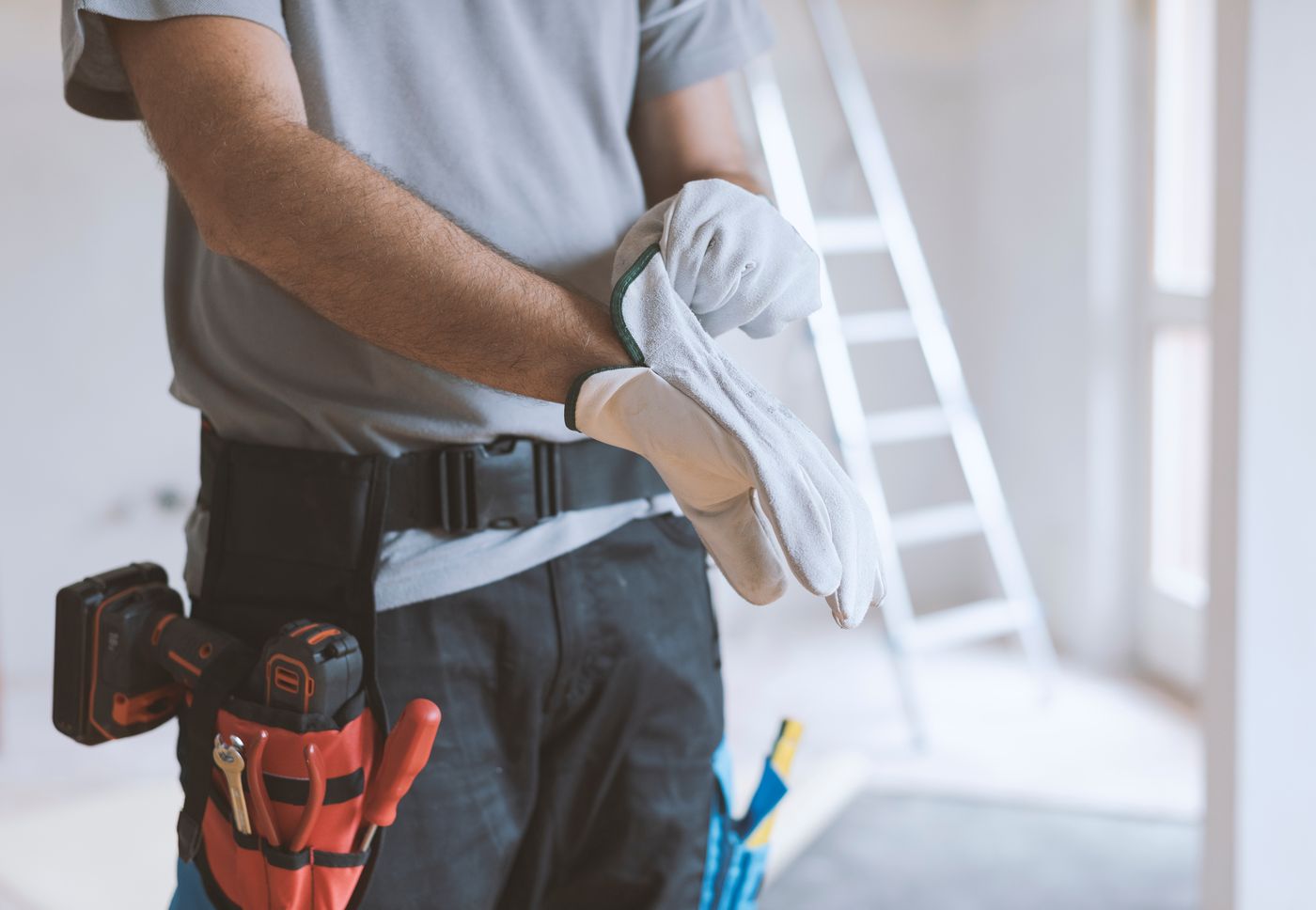 Handwerker mit Schutzhandschuhen bei einer fachgerechten Kleinreparatur